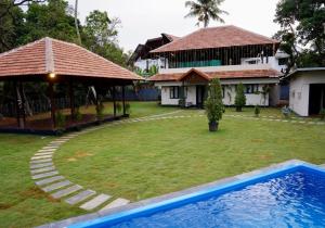 a house with a yard with a swimming pool at Mangrove Bay - Boutique Resort in Cochin