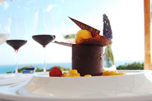 ein Dessert auf einem Teller mit zwei Gläsern Wein in der Unterkunft Magnifique appartement 500m de la plage avec piscine in Porches