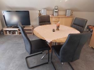 a dining room with a table and chairs and a television at Ferienwohnung Hartmann in Wernigerode