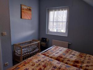 a bedroom with a bed and a crib and a window at Ferienwohnung Hartmann in Wernigerode