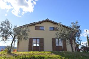 a house on a hill with trees in front of it at Agriturismo Colle Bello in Spoleto
