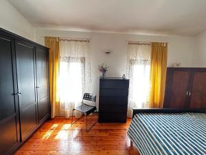 Casa MinolleにあるCasale Gelsomino primo pianoのベッドルーム1室(ベッド1台、ドレッサー、窓2つ付)