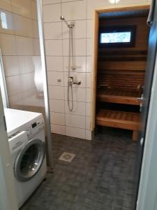 a bathroom with a shower and a washing machine at Majoituspalvelu Nurmi Oy Välitie 3B Saunallinen in Raahe