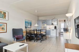 Una sala de estar y una cocina con mesa y sillas. en Holiday Apartment Near Bønnerup, en Glesborg