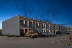 Un edificio con dos coches estacionados en un estacionamiento. en Holiday Apartment Near Bønnerup, en Glesborg