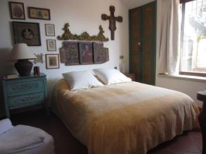 1 dormitorio con 1 cama y 1 cruz en la pared en Casa Taormina, en Taormina