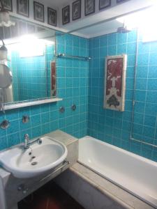 a blue tiled bathroom with a sink and a tub at Casa Taormina in Taormina