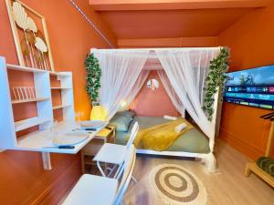 アラスにあるStudio Bali Hyper centre Lit Baldaquinのベッド1台、テーブル、デスクが備わる客室です。