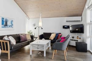 a living room with a couch and a table at Holiday Dream On The West Coast in Brovst