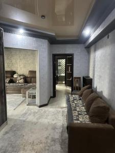 a large living room with a couch and a living room with at Квартира в центре in Bishkek
