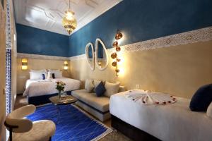 a hotel room with two beds and a couch at Riad Atlas Dama in Marrakech