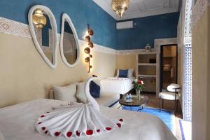 a bedroom with two beds with a swan on it at Riad Atlas Dama in Marrakech