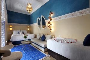 a hotel room with two beds and a couch at Riad Atlas Dama in Marrakech