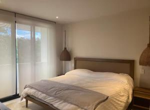 ein Schlafzimmer mit einem Bett und einem großen Fenster in der Unterkunft Tulum groups home for 7 guest with 2 bedrooms Balcony Common Pool Gym Yoga and mini Market Ximbal in Tulum + 33 Fotos