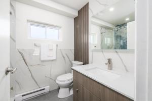 une salle de bains blanche avec toilettes et lavabo dans l'établissement Lions Head Beach Motel & Cottages - WATERFRONT, à Lion's Head 24 autres photos