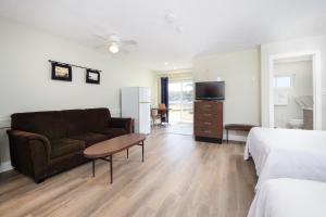 un salon avec un canapé, un lit et une télévision dans l'établissement Lions Head Beach Motel & Cottages - WATERFRONT, à Lion's Head