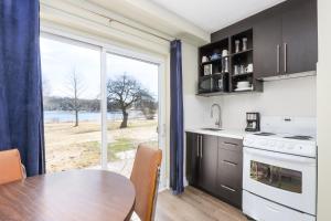 une cuisine avec une table et une grande fenêtre dans l'établissement Lions Head Beach Motel & Cottages - WATERFRONT, à Lion's Head