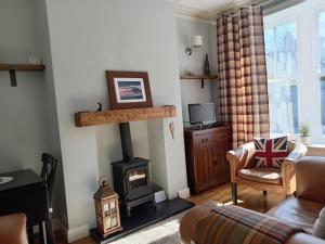 a living room with a wood stove and a couch at Woolly Hill House - Beautiful Townhouse in the Heart of Wooler in Wooler