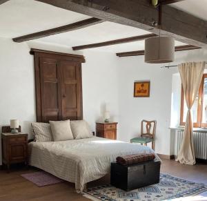 a bedroom with a large bed with a wooden headboard at Maison Garavet in Donnaz