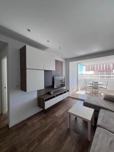 ein Wohnzimmer mit Sofa und Tisch in der Unterkunft MAGNIFICO APARTAMENTO ATICO MARINA D'OR - COSTA CARIBE lll in El Borseral