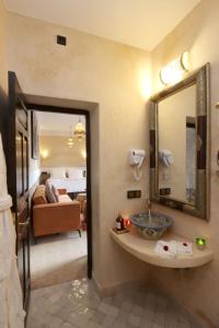 a bathroom with a sink and a living room at Riad Atlas Dama in Marrakech