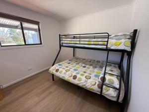 une chambre avec deux lits superposés et une fenêtre dans l'établissement Carron Cottage - Corny Point, à Corny Point