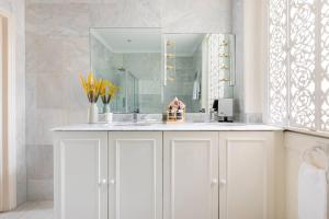 a white bathroom with a sink and a mirror at Secluded Modern Private Apartment by Buckingham Palace in London