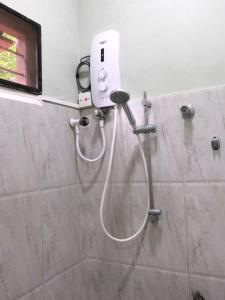 a shower in a bathroom with a hair dryer at SATK INN Jaffna, Kokkuvil in Kokkuvil East