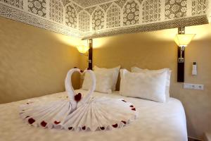 two swans in a dress on a bed at Riad Atlas Dama in Marrakech