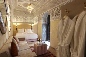 a bedroom with a bed and a couch in a room at Riad Atlas Dama in Marrakech