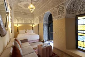 a bedroom with a bed and a couch in a room at Riad Atlas Dama in Marrakech