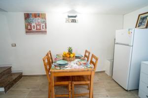 una cucina con tavolo, sedie e frigorifero bianco di La Casetta di Dandrì a Monreale