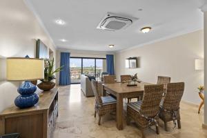 a dining room with a table and chairs at PC410 - Pool View - Perfect for families or group - Close to Palm Beach - 2BR in Palm-Eagle Beach