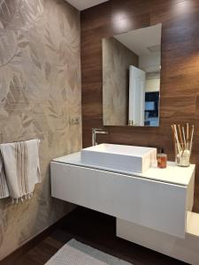a bathroom with a white sink and a mirror at Duplex A Mosquera by Foroplaza Pleno centro Vistas muralla in Lugo +37 photos