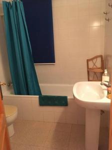 a bathroom with a green shower curtain and a sink at Casa Barbados in Agua Amarga