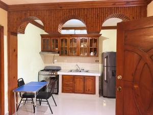a kitchen with a table and a refrigerator at Hotel El Bonao in Higuey