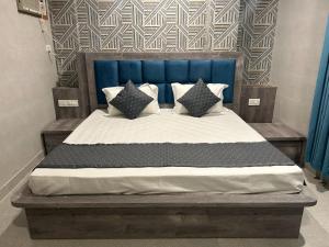 a bedroom with a bed with a blue headboard and pillows at The Brick House in Katra +6 photos