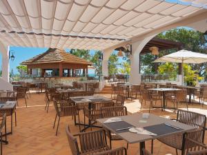 an outdoor restaurant with tables and chairs and a pavilion at Hotel Jardín Tecina in Playa de Santiago