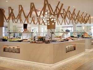 two chefs are preparing food in a restaurant kitchen at Hotel Jardín Tecina in Playa de Santiago