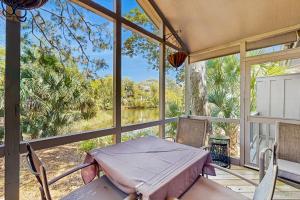 a screened in porch with a table and chairs at Surfscoter 94 in Kiawah Island