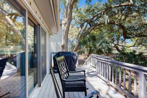 a porch with two chairs and a tree at Surfscoter 94 in Kiawah Island