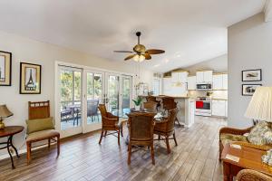 a living room with a table and chairs and a kitchen at Surfscoter 94 in Kiawah Island