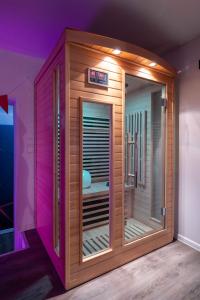 a wooden sauna in a room with purple lights at Suite pour les Amoureux_Val d'Europe Disney in Coupvray +48 photos