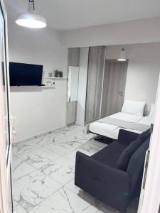 a living room with a couch and a bed at Studio Coral by the sea in Neoi Epivates