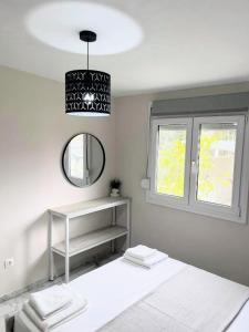 a white room with a bed and a mirror at Studio Coral by the sea in Neoi Epivates