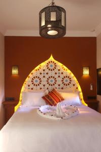 a bedroom with a bed with a moroccan head board at Riad Atlas Dama in Marrakech