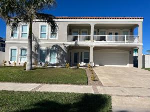 a large white house with a palm tree at FamReunion,EVcharger,3LotsToBeach,HeatedPool,Jacuzzi in South Padre Island
