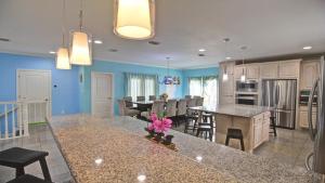 a kitchen and dining room with blue walls and a table at FamReunion,EVcharger,3LotsToBeach,HeatedPool,Jacuzzi in South Padre Island