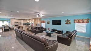 a living room with leather couches and a kitchen at FamReunion,EVcharger,3LotsToBeach,HeatedPool,Jacuzzi in South Padre Island