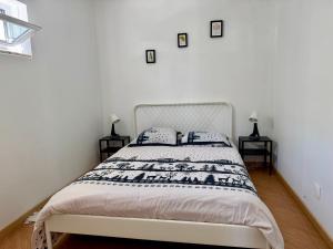 a white bedroom with a bed with two night stands at Maison Miranda nord Portugal in Represas +25 photos